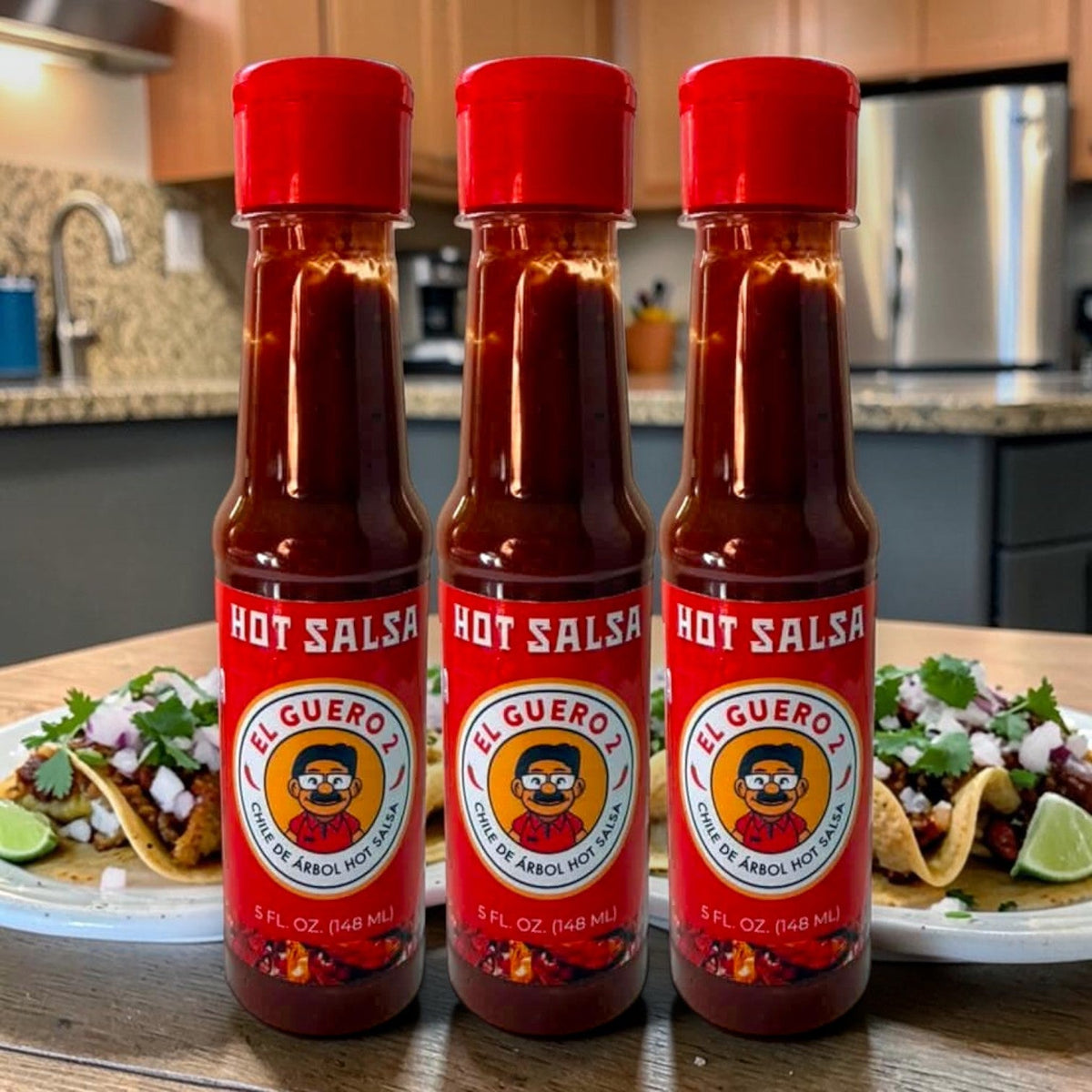 Three bottles of El Guero 2 chile de árbol hot salsa with street tacos